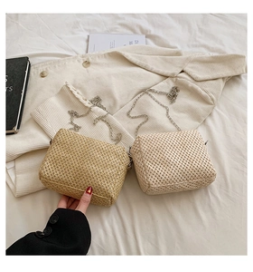 Detail shot of woven straw textures on summer shoulder bags with silver metal chains