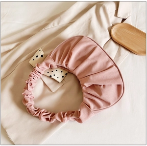 Detail van roze geplooide stoffen handtas met zachte textuur en chic ruche-ontwerp