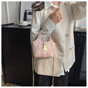 Detail of pink quilted leather mini bag with gold chain strap and square buckle