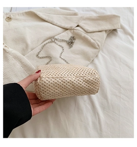 Detailed macro view of beige straw woven fabric texture with thin silver metal chain