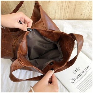 Close-up of brown tote bag showing inner lining, zipper pocket and magnetic closure