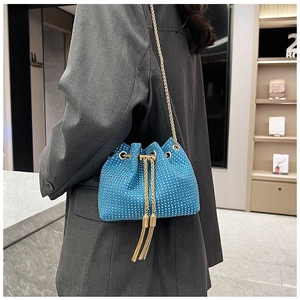 Détail du sac seau bleu brillant en strass avec chaîne dorée et cordon à pompons