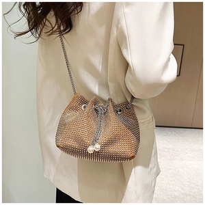 Détail du sac seau en strass avec cordon de perles et bandoulière chaîne sur modèle