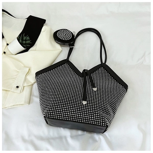 Detail of rhinestone tote bag and small round coin purse on white fabric background