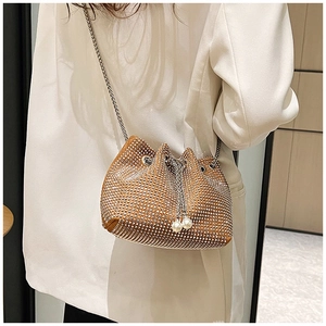 Détail du sac seau marron orné de strass avec breloques perles et bandoulière chaîne