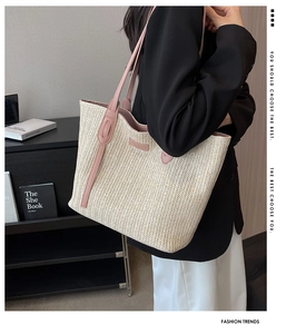 Détail d'un grand sac cabas en paille tissée avec poignées en cuir rose et boucle moderne