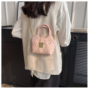 Detail of light pink quilted mini bag with gold hardware and elegant chain strap