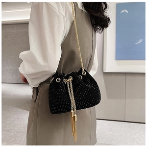 Détail du sac seau noir en strass avec chaîne dorée et glands métalliques longs