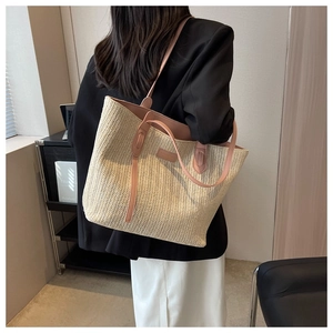 Détail du sac cabas en paille tressée avec poignées en cuir rose et texture crème