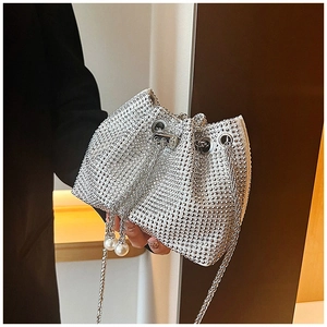 Gros plan du sac seau en strass argenté avec pendentif perle et chaîne de serrage