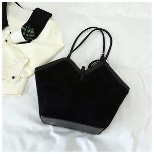 Detailed close-up of a large black tote bag with suede texture and V-shape cut