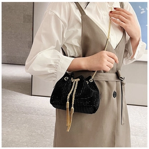 Détail du sac seau noir en strass avec bandoulière chaîne dorée et glands frangés