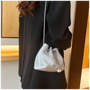 Détail du sac seau en strass argenté avec cordon en cristal et perles sur un costume noir