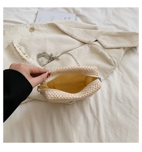 Detail of beige straw bag with metal zipper yellow fabric lining and mesh inner pocket