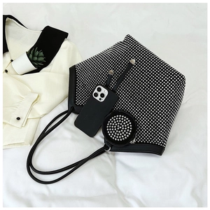 Detail of rhinestone tote bag with matching round coin purse on white fabric background