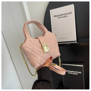 Close-up of pink quilted mini bag showing gold metal buckle and leather chain strap
