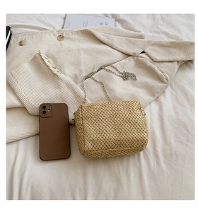 Detailed straw shoulder bag with woven texture, silver chain strap, and casual style