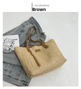 Détail de la texture de paille tressée marron et des coutures sur le sac fourre-tout