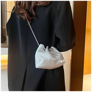 Détail du sac seau argenté en strass avec cordon de serrage et perles décoratives sur le côté
