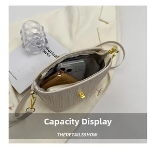 Capacity display of straw bucket bag showing phone and wallet inside open main compartment