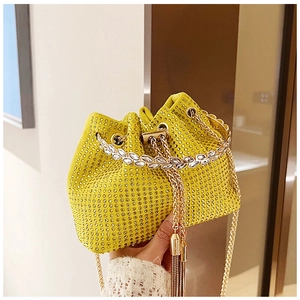 Détail d'un sac seau jaune citron avec strass de luxe et chaîne dorée chic