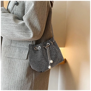 Détail du sac seau noir en strass avec cordon en perles et bandoulière en chaîne