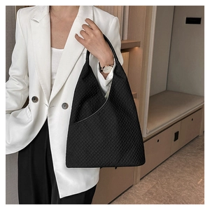 Detailaufnahme der schwarzen Stepptasche mit eleganten Griffen und Textur