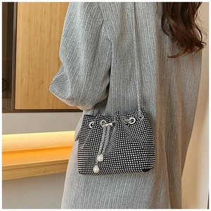 Vue détaillée du sac seau noir orné de perles blanches et d'une bandoulière en chaîne argent
