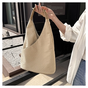 Makro-Detail einer beigen minimalistischen Schultertasche mit 3D-Rautenmuster-Gewebe