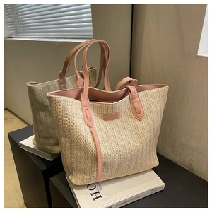 Détail du sac cabas tissé beige avec poignées en cuir rose et écusson de marque