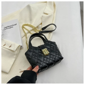 Detail of black quilted leather mini bucket bag with gold chain and metal lock