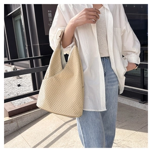 Detailansicht einer beigen Hobo-Tasche mit geometrischer Prägung und geräumigem Design