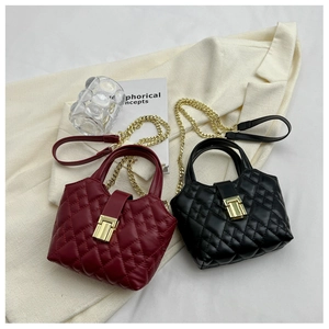 Detail view of burgundy and black quilted mini tote bags with golden chain straps