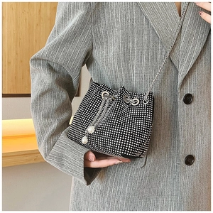 Détail du sac seau strass noir avec chaîne argentée et glands en perles sur le cordon