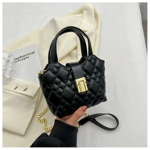 Close-up of black quilted bucket bag featuring a gold buckle and luxury chain strap