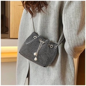 Détail du sac seau en strass étincelants avec chaîne argentée et cordon en perles