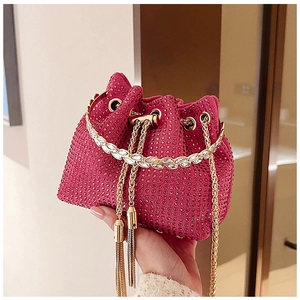 Détail du sac seau à strass rose rouge avec poignée feuille dorée et finitions à glands