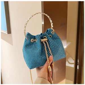 Détail du sac seau de soirée bleu à strass avec poignée en métal doré et pompons