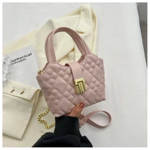 Detail of light pink quilted mini handbag with gold metal lock and chain strap for women