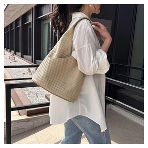 Detail einer beigen gesteppten Hobo-Tasche mit Strukturmuster über der Schulter