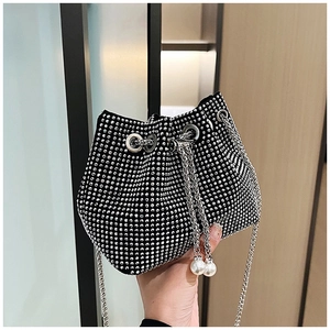 Détail du sac seau en strass avec fermeture à cordon et accents de grosses perles