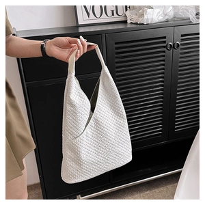 Detailansicht einer weißen strukturierten Hobo-Tasche mit breitem Schultergurt-Stil