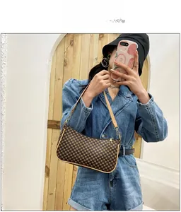 Dettaglio della borsa a mezzaluna con monogramma geometrico vintage e finiture in pelle