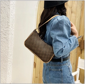Dettaglio della borsa a mezzaluna color caffè con texture geometrica e tracolla sottile