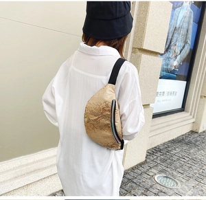 Détail du sac ceinture doré à motif crocodile avec fermeture éclair irisée et sangle