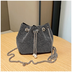 Détail du sac seau en strass avec chaîne argentée et cordon orné d'une perle blanche