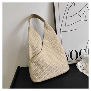 Detailaufnahme der Steppung und des Ledergriffs an einer cremefarbenen Hobo-Tasche