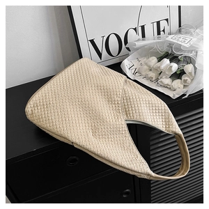 Nahaufnahme der beigen Hobo-Tasche mit Bubble-Textur auf einem schwarzen Schrank