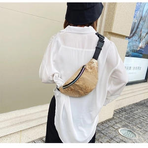 Détail du sac ceinture à motif crocodile doré porté par un mannequin dans la rue
