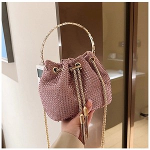 Gros plan du sac seau rose en strass avec chaîne dorée et cordon de serrage